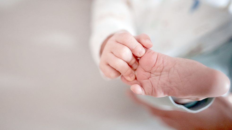 Ein Baby greift mit den Fingern nach seinem Fuß. 2021 haben es zwei Vornamen an die Spitze des Namen-Rankings in Ostfriesland geschafft: Emma und Milan. Foto: Strauch/dpa