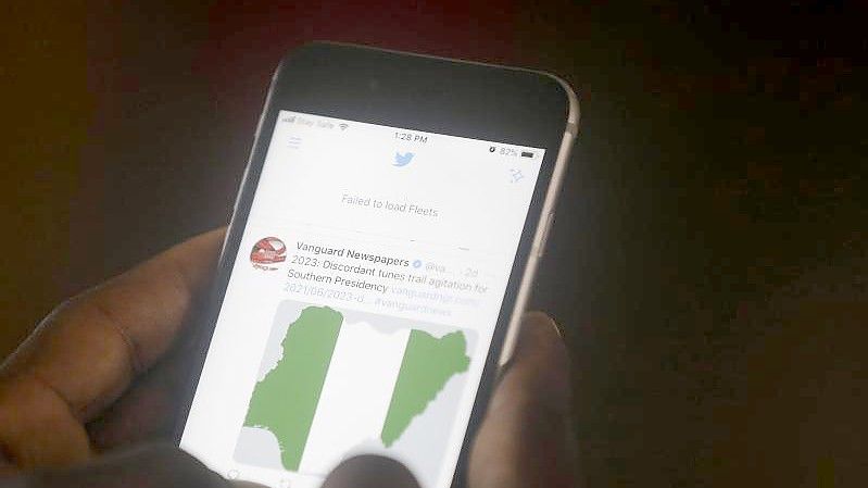 Ein Mann in Lagos benutzt sein Handy, um Nachrichten auf Twitter zu lesen. Foto: Sunday Alamba/AP/dpa