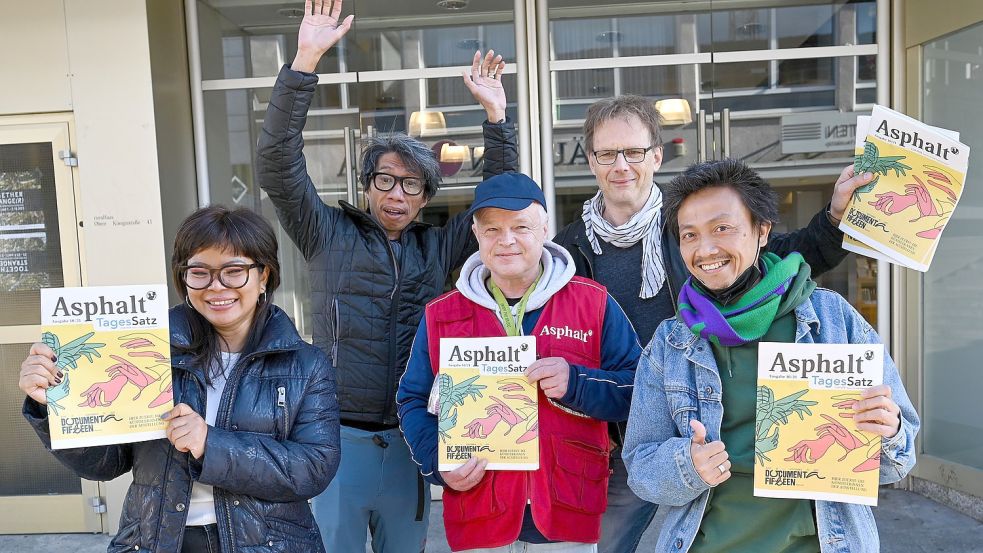 Da schien die Welt für die Documenta noch in Ordnung: Daniella Fitriab (l-r), Iswanto Hartono (beide vom Künstlerkollektiv ruangrupa), Stefan Marx (Verkäufer der Straßenzeitung „Asphalt“), Volker Macke (Redaktionschef „Asphalt“) und Reza Afisina (ruangrupa) präsentierten vor dem ruruHaus die Oktober-Ausgabe der „Asphalt“ mit der kompletten Künstlerliste der ausstellenden Künstlerinnen und Künstler der «documenta fifteen». Jetzt muss sich die Weltkunstschau mit dem Vorwurf auseinandersetzen, auf ihrer Künstlerliste würden antisemitische Positionen unterstützt. Foto: Uwe Zucchi/dpa Foto: Uwe Zucchi
