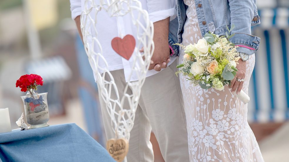 Ein Paar heiratet am Strand von Juist. Das Standesamt der Nordsee-Insel bietet seit 2019 Trauungen unter freiem Himmel an. Archivfoto: S. Schuldt/dpa