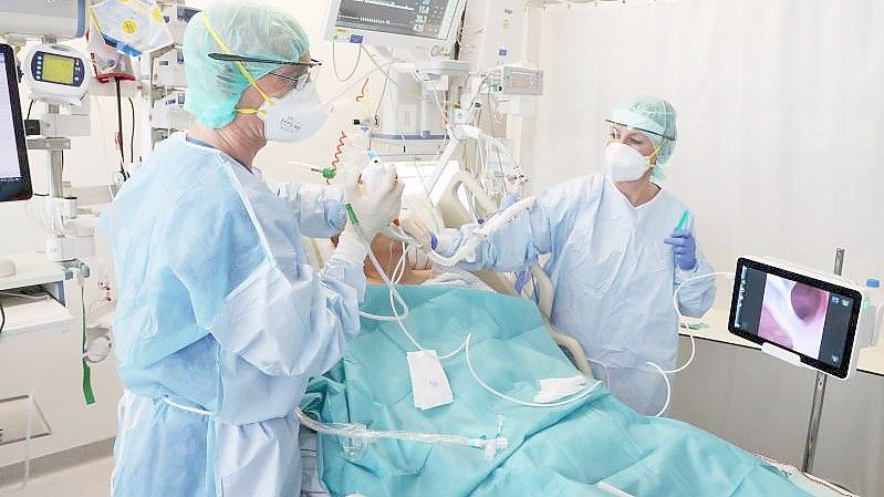 Ärzte und Pfleger betreuen einen Patienten auf der Covid-19-Intensivstation im SRH Waldklinikum in Gera. Foto: Bodo Schackow/dpa-Zentralbild/dpa