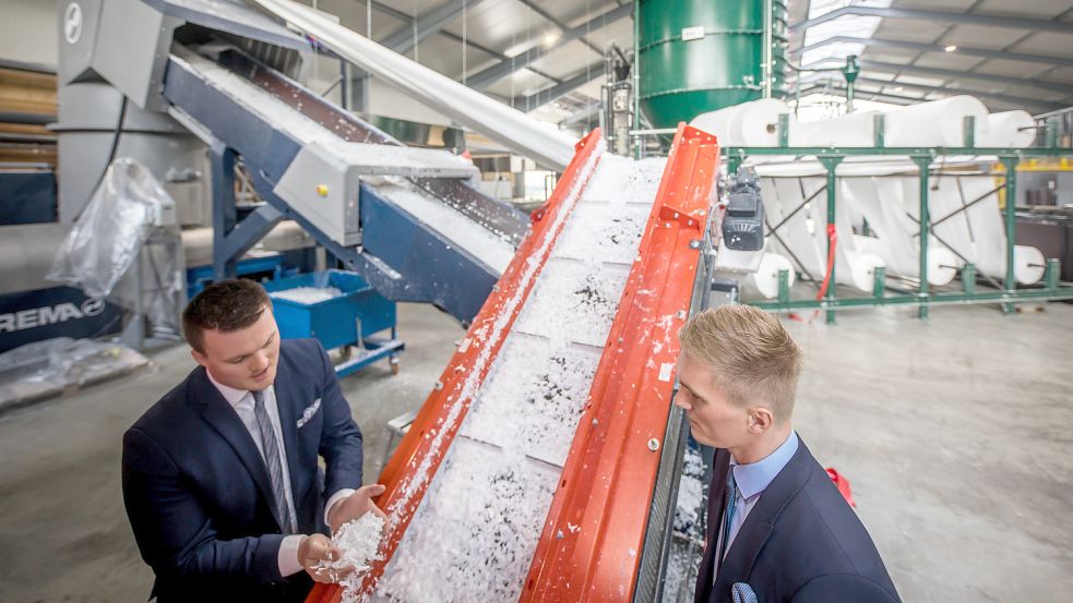 •Arne Bohlen (links) prüft frisch geschredderten Kunststoff, der über Förderbänder in den Extruder transportiert wird. Stefan Bohlen sieht ihm dabei zu. Eine nahezu baugleiche Anlage soll jetzt noch in Halle 13 auf dem Firmengelände entstehen. Foto: Cordsen/Archiv