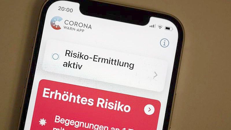 Eine Corona-Warn-App zeigt auf einem Handy ein erhöhtes Risiko an, mit einer an Corona infizierten Person Kontakt gehabt zu haben. Foto: Bernd Weißbrod/dpa