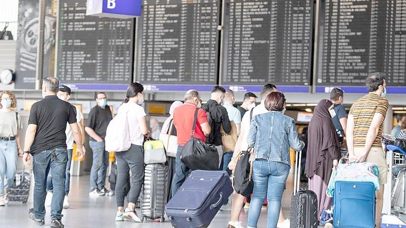 Passagiere warten auf dem Frankfurter Flughafen. Foto: Boris Roessler/dpa