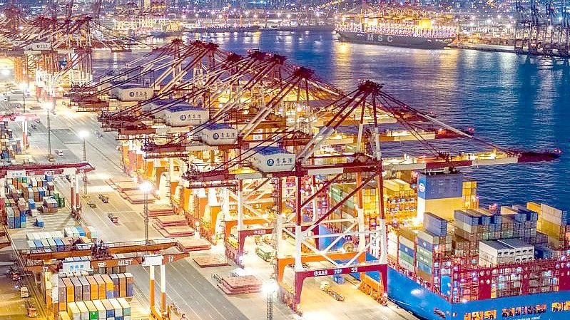 Containerschiffe liegen im nächtlich beleuchteten Containerterminal des Hafens von Qingdao. Foto: Yu Fangping/SIPA Asia via ZUMA Wire/dpa