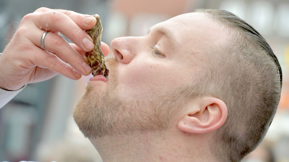 Für alle, die sich mit der Delikatesse nicht auskennen, macht es Berend Schulz vor: Die Austern werden direkt aus der Schale geschlürft. Foto: Ortgies