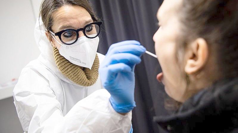 In einem Testzentrum wird von einer Mitarbeiterin ein Abstrich für einen Corona-Schnelltest genommen. Foto: Sina Schuldt/dpa