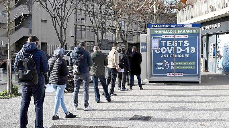 Menschen stehen vor einer Apotheke in Marseille an, um einen Corona-Schnelltest zu erhalten. Foto: Nicolas Tucat/AFP/dpa