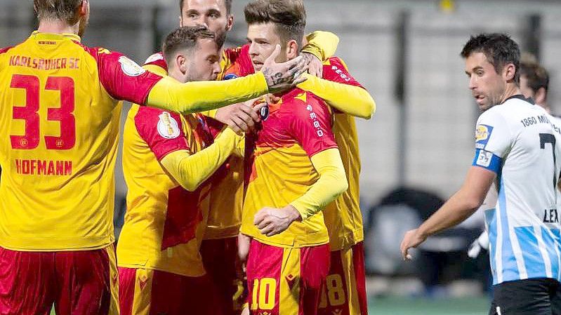 Die Spieler vom Karlsruher SC feiern Elfmeter-Torschütze Marvin Wanitzek. Foto: Sven Hoppe/dpa