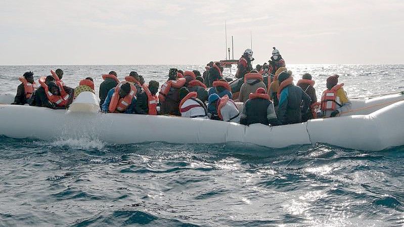 Menschen in einem in Not geratenen Boot auf dem Mittelmeer. Foto: Max Brugger/Sea-Watch/dpa