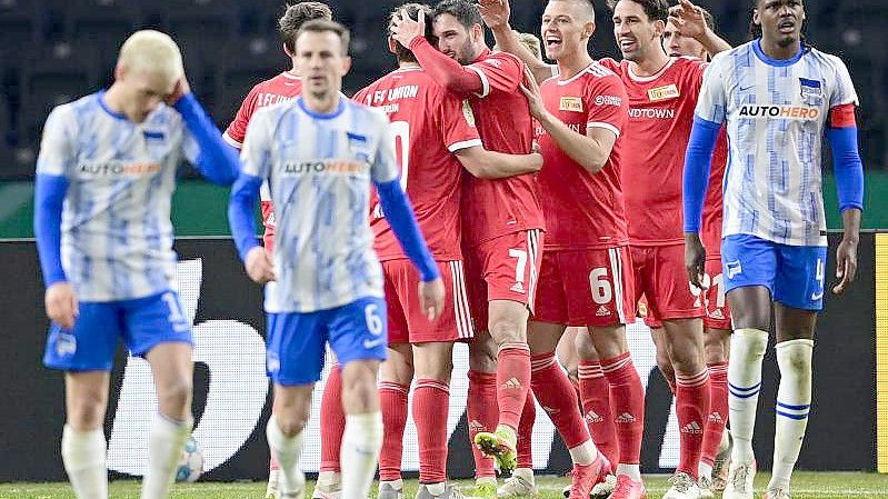 Die Spieler von Union Berlin (in rot) feiern das 2:0 gegen Hertha BSC. Foto: Sören Stache/dpa