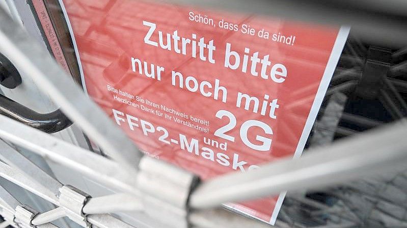 Am Eingang eines Ladens in der Ravensburger Innenstadt wird auf die Maskenpflicht und die 2G-Regel hingewiesen. Foto: Felix Kästle/dpa