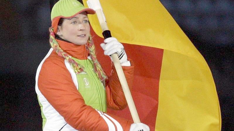 Eisschnelläuferin Claudia Pechstein trägt 2006 bei der Abschlussfeier der Olympischen Winterspiele in Turin die deutsche Fahne. Foto: Matthias Schrader/dpa