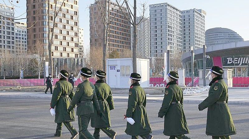 Polizisten patrouillieren in der Nähe des Athletendorfs in Peking. Foto: -/kyodo/dpa