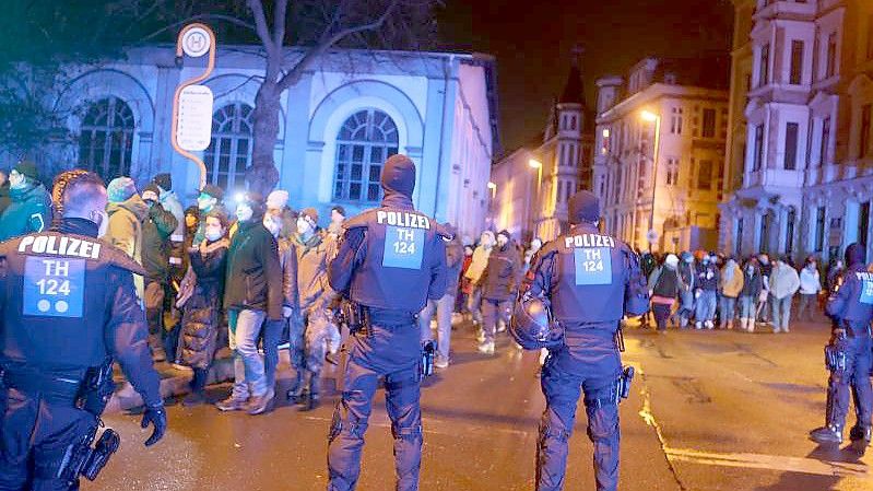 Teilnehmer einer Demonstration gegen die Corona-Maßnahmen gehen durch die Innenstadt von Gera und werden von der Polizei begleitet. Foto: Bodo Schackow/dpa-zentralbild/dpa