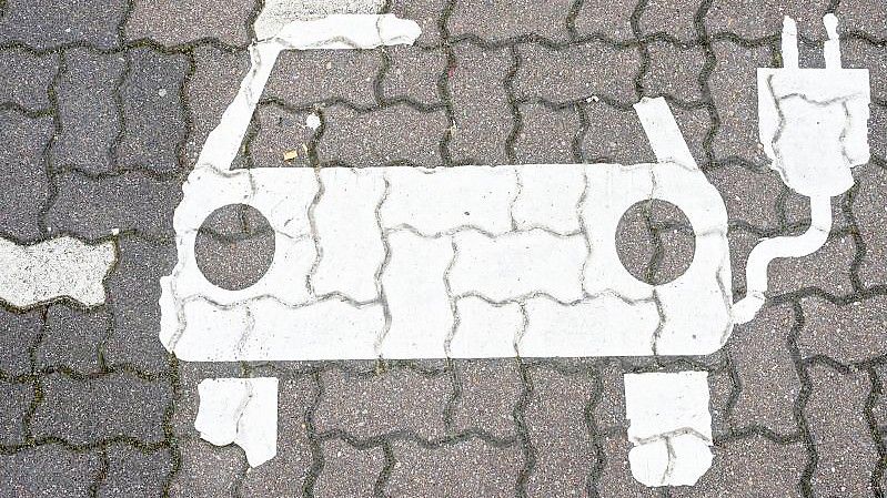 Ein Symbol markiert einen Parkplatz für Elektroautos an Ladesäulen für E-Auto an einem Rastplatz. Foto: Julian Stratenschulte/dpa
