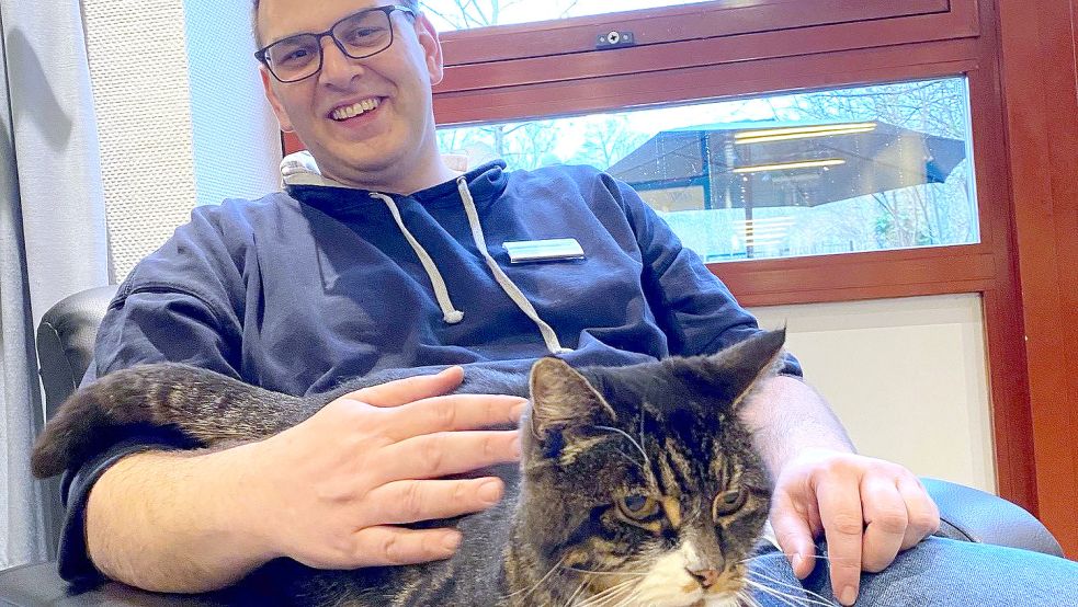 Pfleger Manuel Goldenstein mit Arnold auf dem Schoß: Das Tier hilft vielen Patientinnen und Patienten Erlebtes zu verarbeiten. Fotos: Klinikum Emden