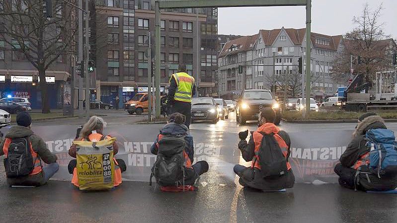 Aktivisten einer Gruppe, die sich „Aufstand der letzten Generation“ nennt, blockieren in Berlin-Steglitz die Autobahn-Zufahrt. Foto: Paul Zinken/dpa