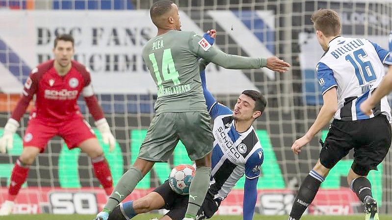 Bielefelds Guilherme Ramos (r) im Kampf um den Ball mit Mönchengladbachs Alassane Plea (l). Foto: Friso Gentsch/dpa