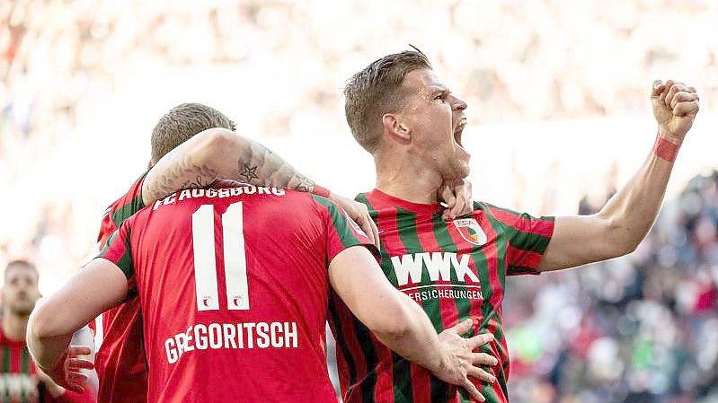 Florian Niederlechner (r) jubelt mit Torschütze Michael Gregoritsch (l) von Augsburg über das 1:0. Foto: Matthias Balk/dpa