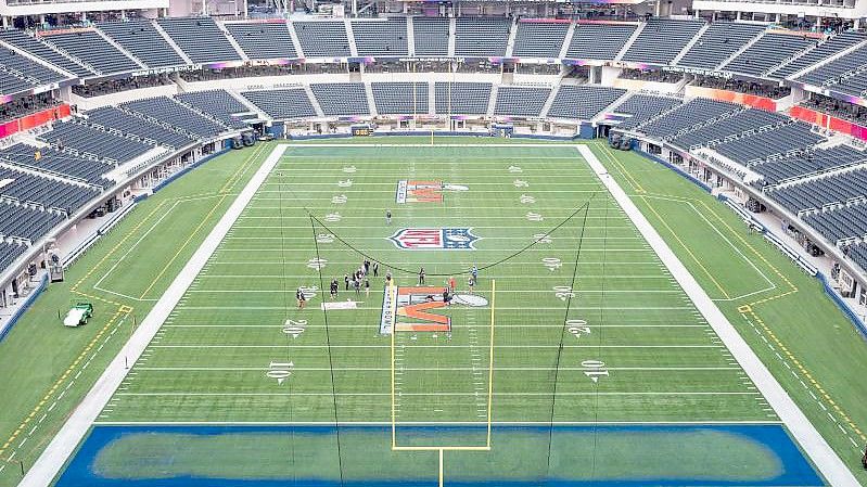 Arbeiter malen das Logo des Super Bowl LVI auf das Spielfeld im SoFi Stadion. Foto: Maximilian Haupt/dpa