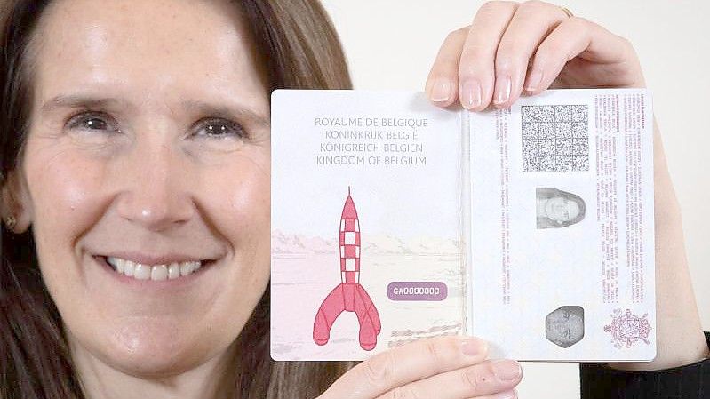 Die belgische Außenministerin Sophie Wilmes mit dem neuen belgischen Reisepass mit einer Zeichnung der Rakete von "Tim und Struppi". Foto: Benoit Doppagne/BELGA/dpa