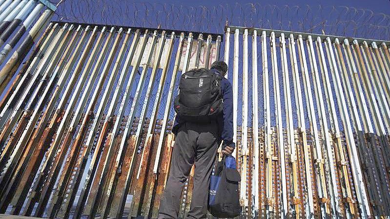 Ein Mann steht an der US-mexikanischen Grenze in Tijuana. Foto: Marco Ugarte/AP/dpa
