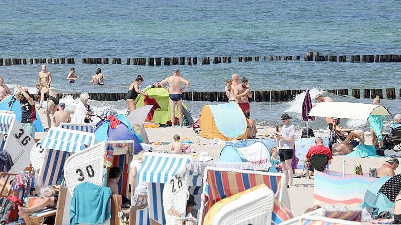 Gut gefüllt ist der Ostseestrand vor dem Yachthafen in Kühlungsborn. Doch die Maßnahmen in der Corona-Pandemie haben dem Tourismus in Deutschland auch das zweite Jahr in Folge hart zugesetzt. Foto: Bernd Wüstneck/dpa-Zentralbild/dpa