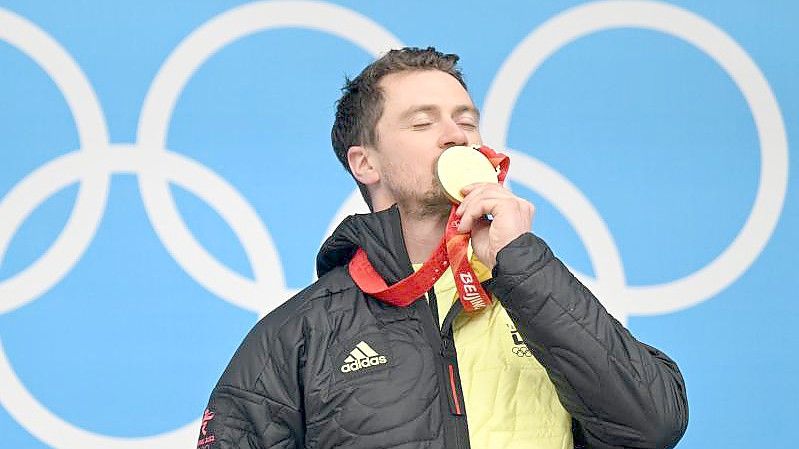 Der 35-jährige Rodler Johannes Ludwig feiert mit seiner Goldmedaille auf dem Podium. Foto: Robert Michael/dpa-Zentralbild/dpa