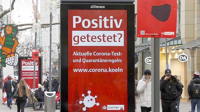 Es ist noch nicht vorbei: eine Corona-Hinweistafel in der Kölner Innenstadt. Foto: Oliver Berg/dpa