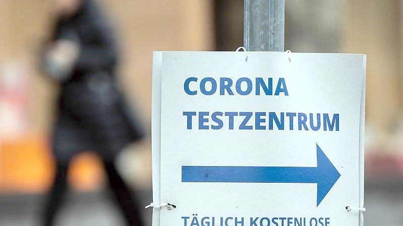 Ein Pappschild weist die Richtung zu einem Corona-Testzentrum in Düsseldorf. Foto: Federico Gambarini/dpa