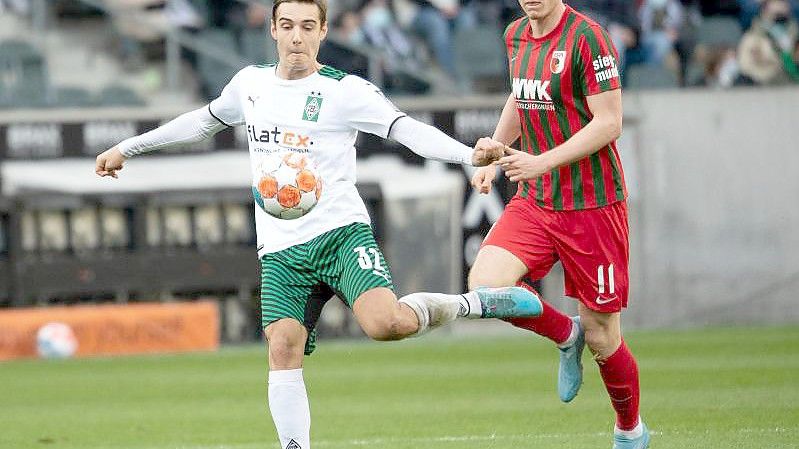 Mönchengladbachs Florian Neuhaus (l) und Augsburgs Michael Gregoritsch kämpfen um den Ball. Foto: Federico Gambarini/dpa