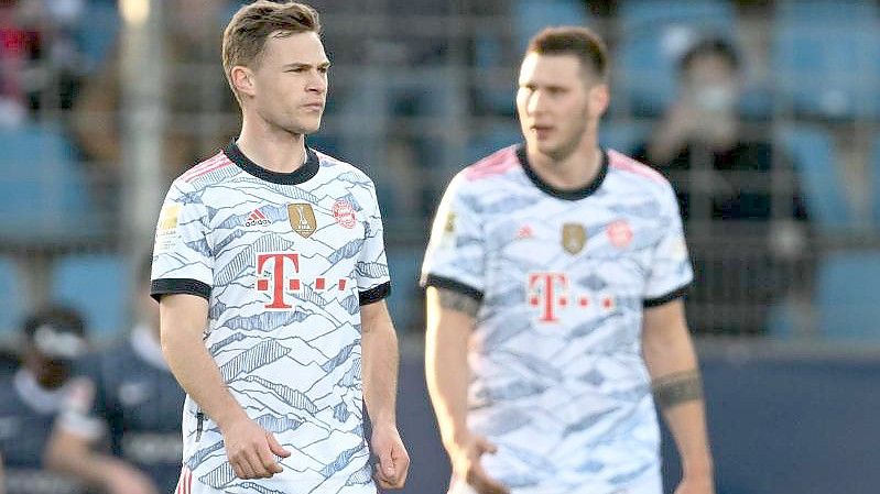 Münchens Joshua Kimmich (l) und Niklas Süle stehen enttäuscht auf dem Platz. Foto: Bernd Thissen/dpa