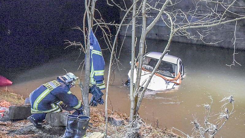 Das Auto liegt unterhalb der Brücke am Fluss Kocher in Künzelsau. Foto: Fabian Koss/onw-images/dpa