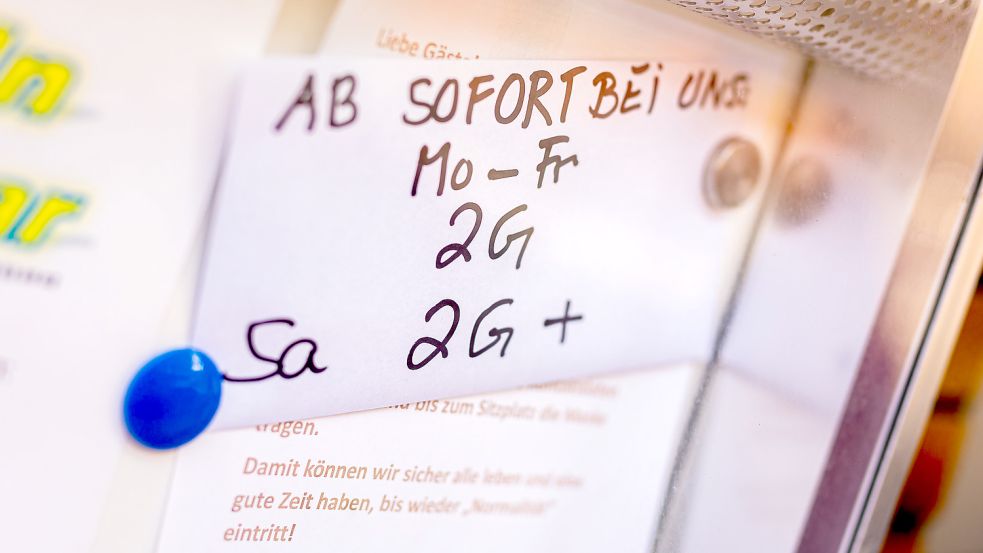 Auf einem handschriftlichen Schild im Aushang einer Kneipe wird auf Regeln zur Eindämmung der Corona-Pandemie hingewiesen. Foto: Moritz Frankenberg/dpa