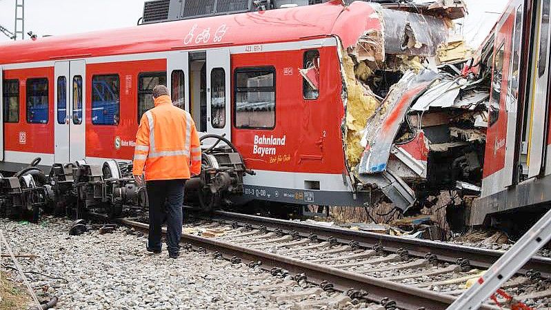 Ein Mitarbeiter der Deutschen Bahn geht an der Unfallstelle zweier aufeinander geprallter S-Bahnen in der Nähe des Bahnhofes Ebenhausen-Schäftlarn vorüber. Foto: Matthias Balk/dpa