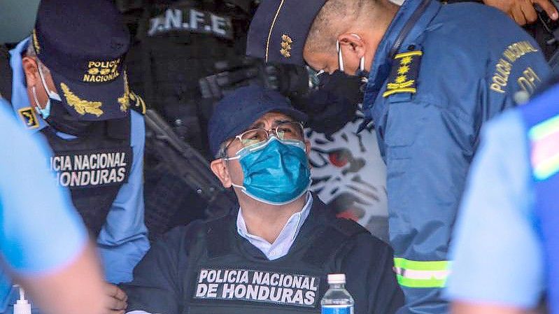 Juan Orlando Hernandez spricht mit Polizeibeamten nach seiner Festnahme in seinem Haus. Foto: Inti Ocon/dpa