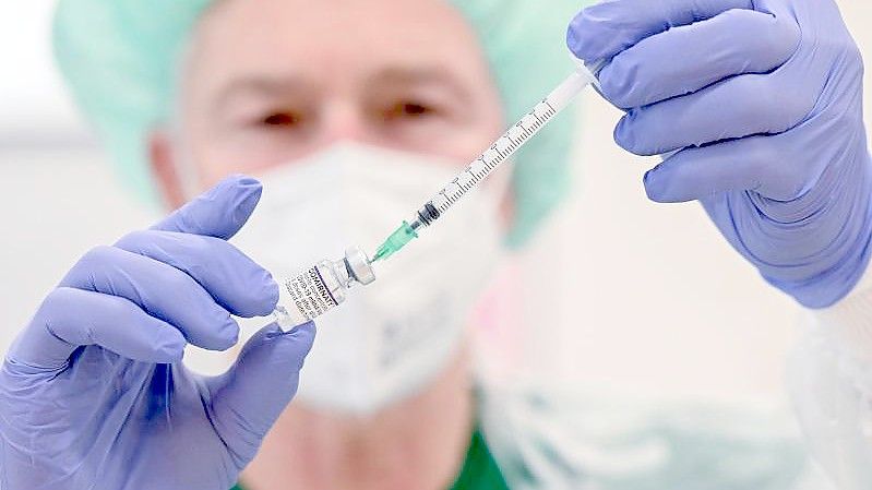 Ein Mitarbeiter des Klinikums Stuttgart bereitet in einer Impfstation eine Spritze für eine Impfung gegen das Coronavirus vor. Foto: Bernd Weißbrod/dpa