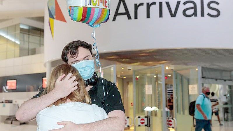 Zwei Personen umarmen sich in der Ankunftshalle am Flughafen Perth. Australien öffnet nach fast zwei Jahren wieder seine Grenzen für internationale Touristen. Foto: Richard Wainwright/AAP/dpa