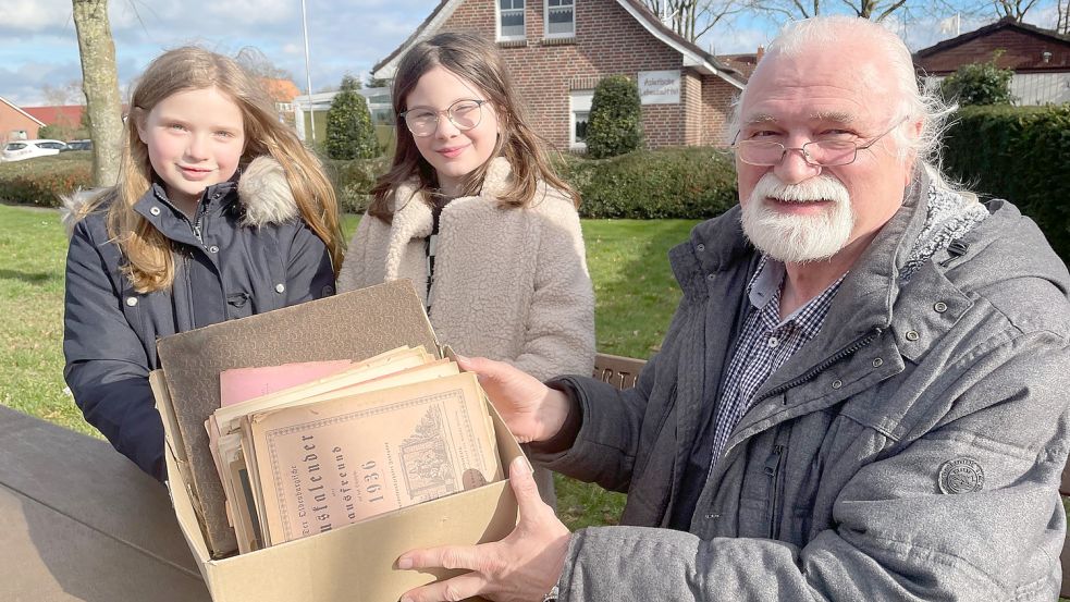 Jasmin Fuss (von links) und Lea Broermann haben ihrem Lehrer Eckhard Janssen ihren Fund gezeigt. Der hat die Kiste zum GA gebracht. Foto: Janßen