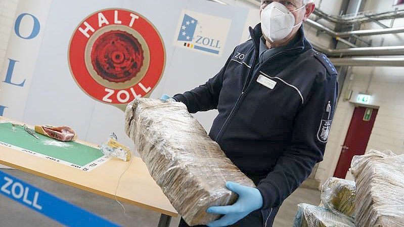 Der stellvertretende Pressesprecher des Zollfahndungsamtes Hamburg Andreas Franke mit einem Teil des sichergestellten Kokains. Foto: Marcus Brandt/dpa
