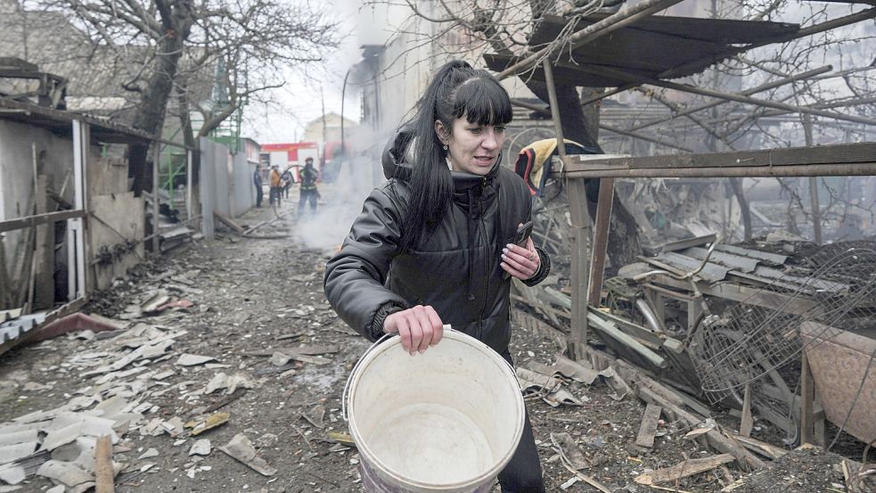 Ukraine, Mariupol: Eine Frau geht an den Trümmern nach russischem Beschuss vorbei. Foto: Maloletka/AP/dpa