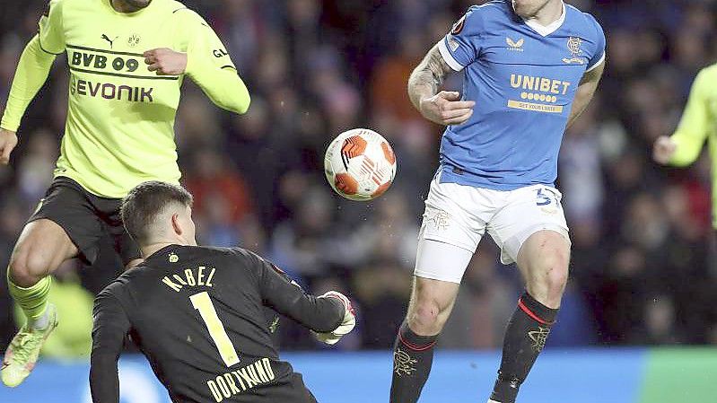 Dortmunds Torhüter Gregor Kobel blockt einen Torschuss von Glasgows Scott Arfield (l). Foto: Scott Heppell/AP/dpa
