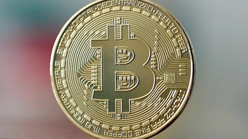 Eine Bitcoin Münze steht auf einem Tisch. Experten sagen, Russland könnte das Swift-System mit Krypto-Währungen teilweise umgehen und damit auch einen Teil der Sanktionen. Foto: Ina Fassbender/dpa