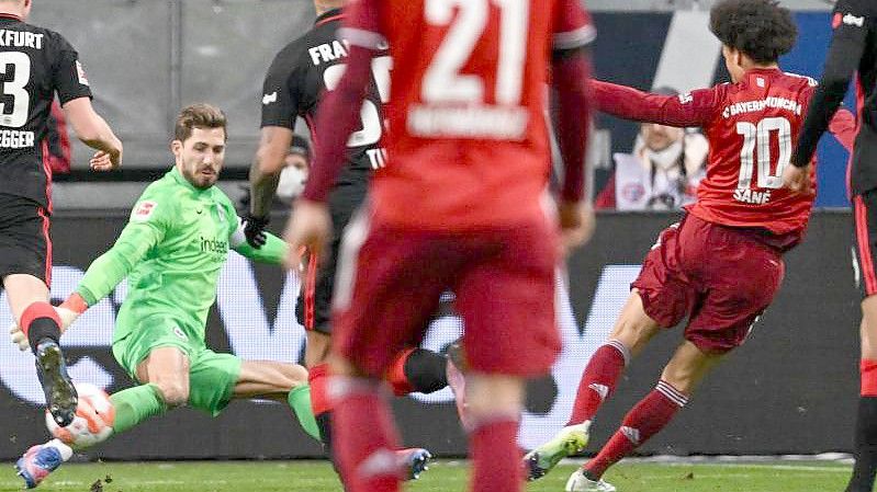 Bayerns Leroy Sané (r) erzielt das Tor zum 1:0 gegen Frankfurts Torwart Kevin Trapp. Foto: Arne Dedert/dpa