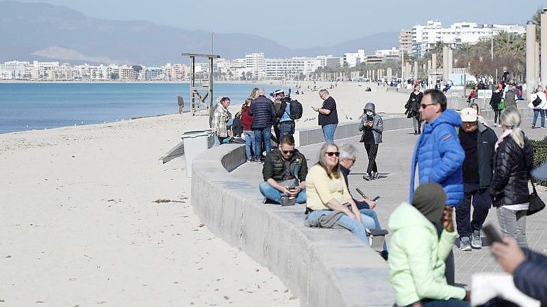 Touristen genießen die Februarsonne auf Mallorca. Die Insel bereitet sich auf die Saison vor. Foto: Clara Margais/dpa