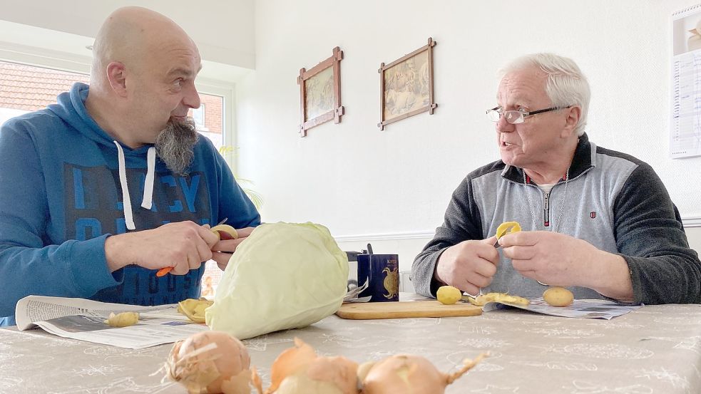 Thomas Hartmann-Rieks (links) betreut Thomas Lössl in der Senioren-WG in Bunde. Das gemeinsame Kochen steht täglich auf dem Programm. Fotos: Tomé