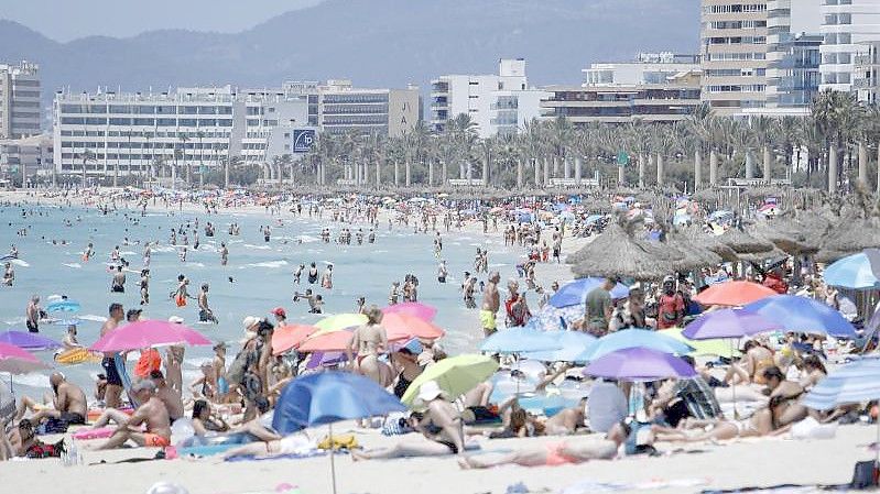 Touristen am Strand von Arenal. Corona-Reisebeschränkungen werden auf Mallorca deutlich gelockert oder fallen ganz. Foto: Clara Margais/dpa