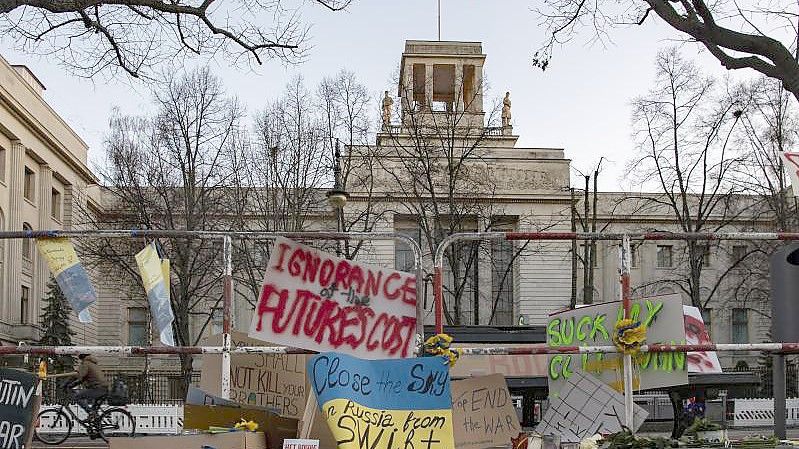 An den Absperrgittern vor der russischen Botschaft in Berlin haben Menschen Plakate angebracht. Foto: Paul Zinken/dpa