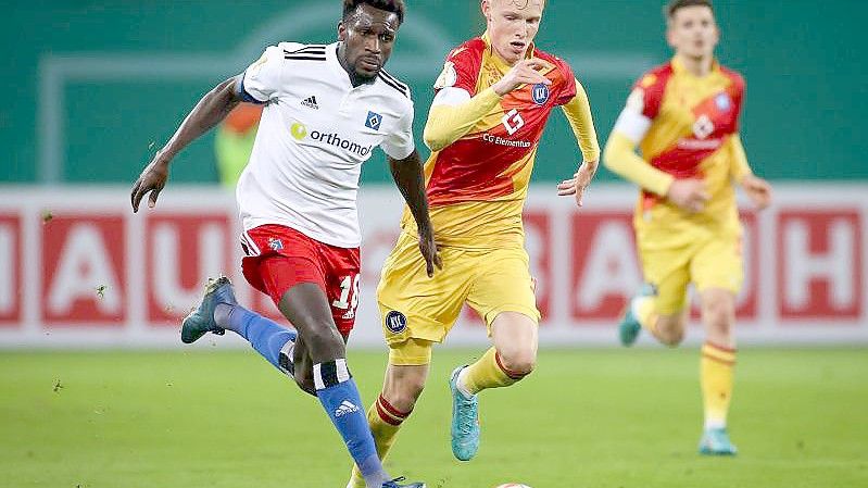 Bakery Jatta (l) vom Hamburger SV und Karlsruhes Tim Breithaupt kämpfen um den Ballbesitz. Foto: Christian Charisius/dpa